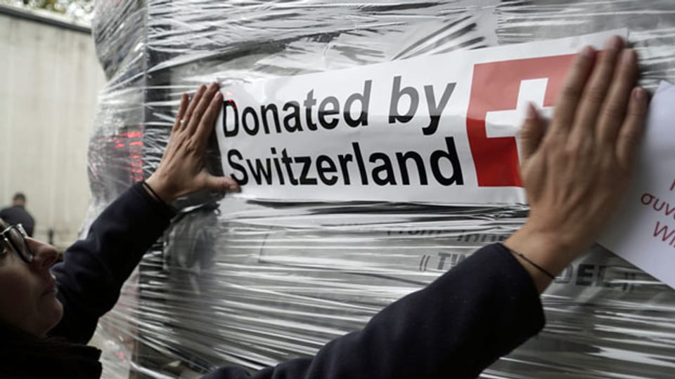 Ein Mitarbeiter des DEZA verlädt Hilfsgüter für Flüchtlinge und Migranten. Symbolbild.