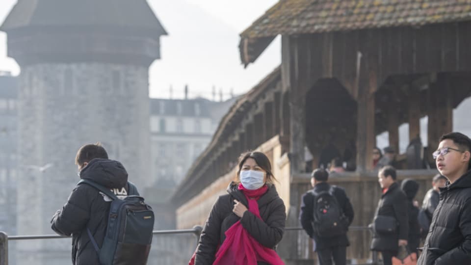 Touristin mit Schutzmaske vor der Luzerner Kapellbrücke