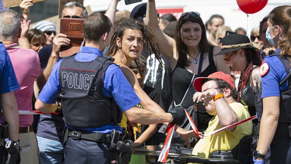 Polizisten mit Absperrbändern bei einer Demonstration gegen den Coronavirus Lockdown.