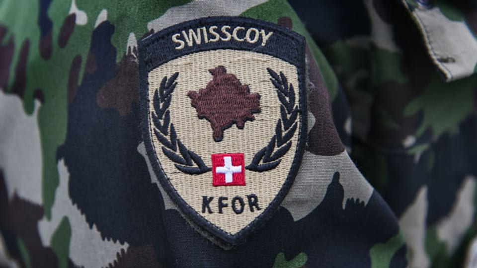 Das Logo von Swisscoy auf einer Schweizer Militäruniform.