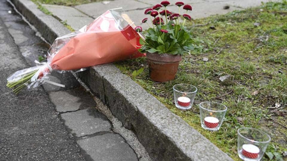 Blumen und Kerzen liegen am Strassenrand in einem Quartier in Basel, wo der 7jährige Junge getötet wurde.
