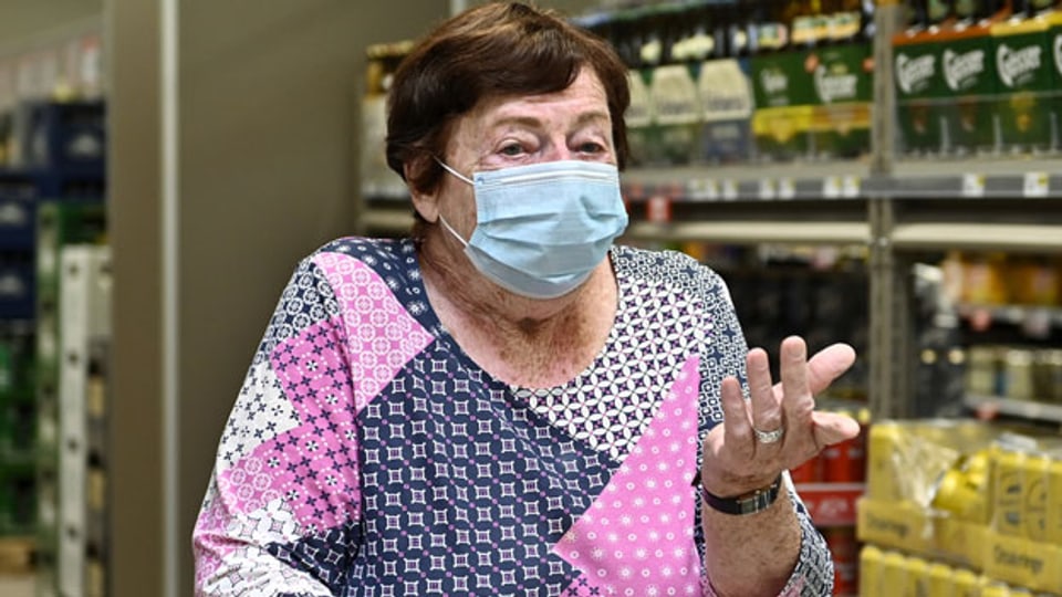 Eine Frau mit Schutzmaske in einem Supermarkt. Symbolbild.