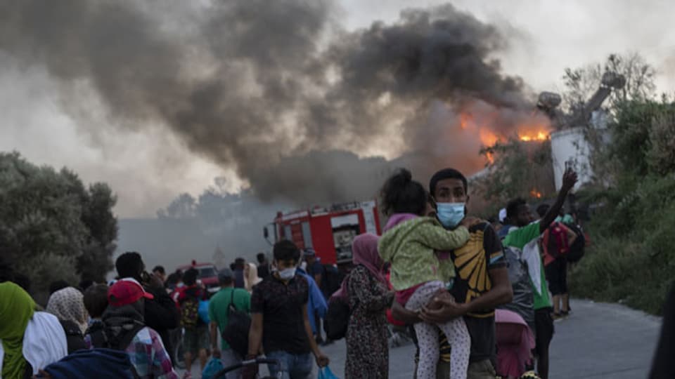 Flüchtlinge aus dem Flüchtlingslager Moria auf Lesbos fliehen vor dern Flammen.
