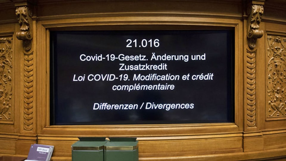Ein Bildschirm zeigt während der Frühlingssession im Nationalratssaal das Geschäft «Covid-19-Gesetz. Änderung und Zusatzkredit» an.
