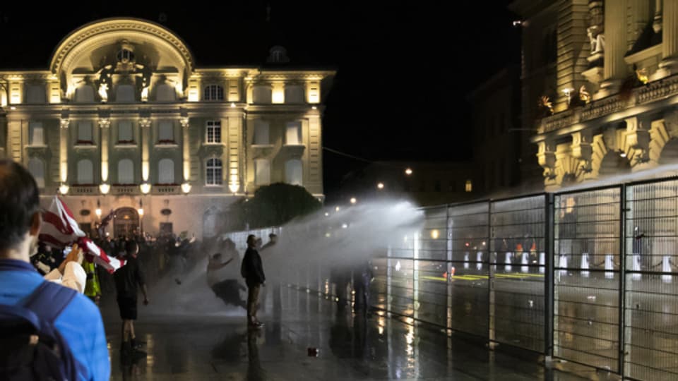 Die Polizei hält Demonstrierende mit dem Wasserwerfer auf Distanz