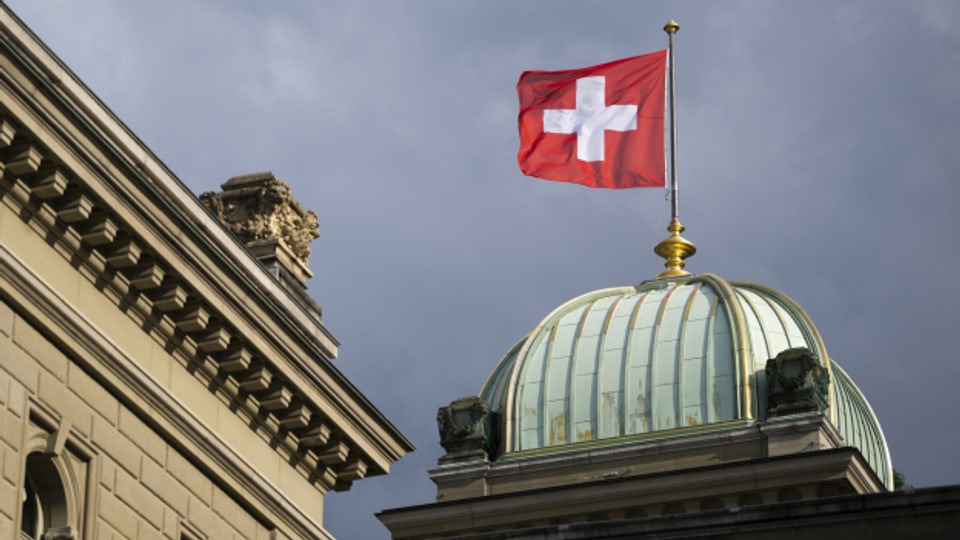 Eine Schweizer Fahne weht über dem Bundeshaus