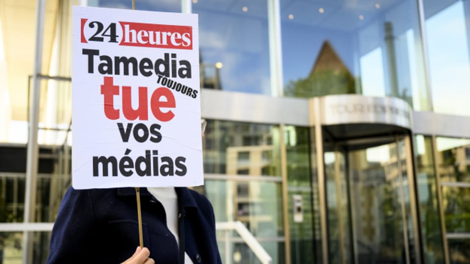 Ein Journalist protestiert vor dem Edipresse-Gebäude in Lausanne gegen die Entlassungen bei Tamedia.