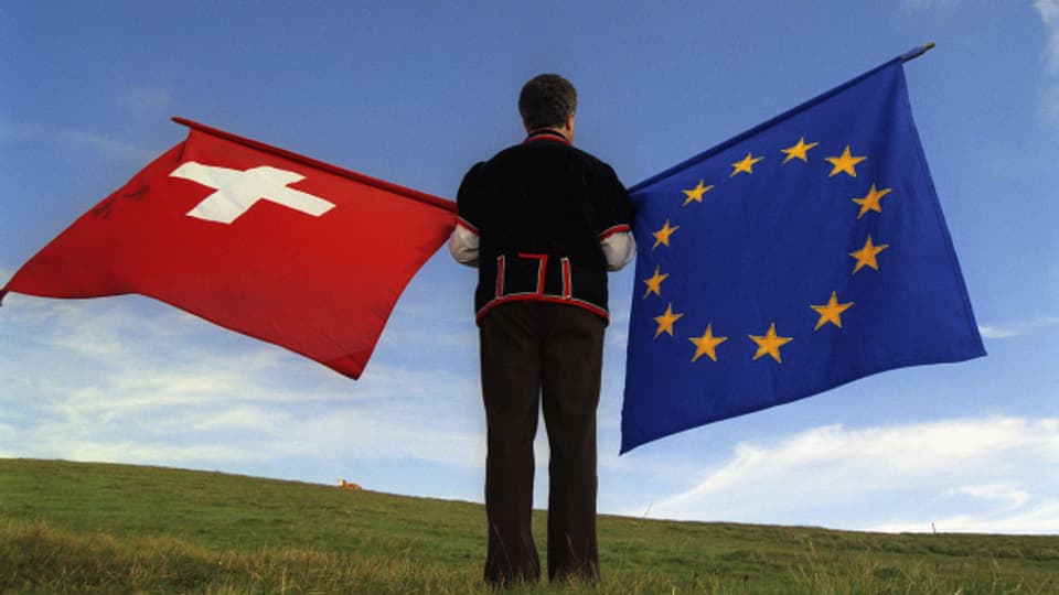 Ein Fahnenschwinger mit einer Schweizer und einer EU-Fahne