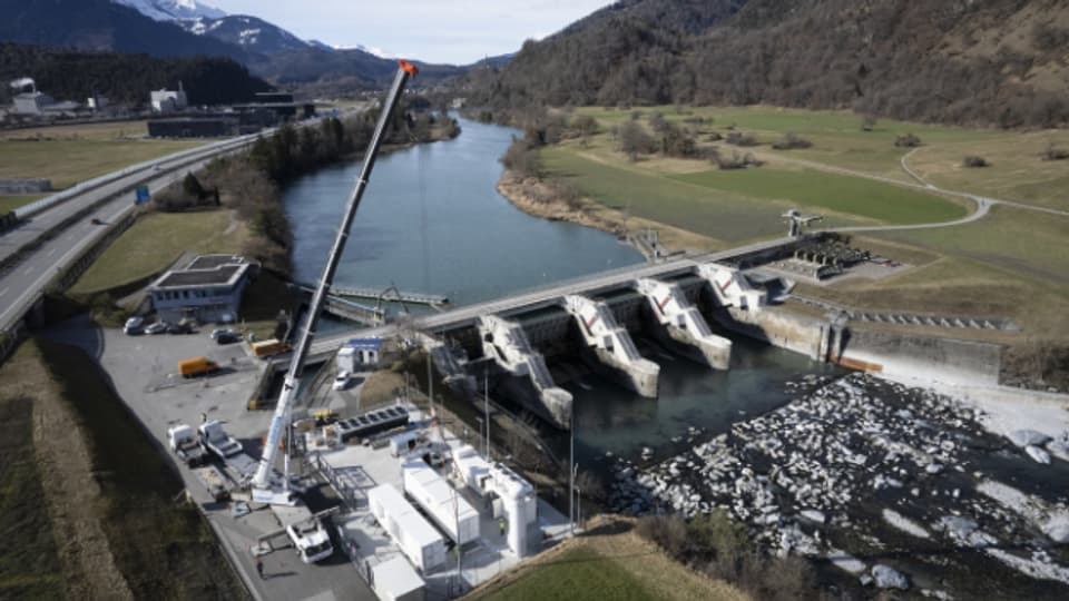 Anlieferung des Elektrolyseurs der Wasserstoffanlage des Energieunternehmens Axpo (links im Bild), beim Wasserkraftwerk Reichenau, Ein Elektrolyseur spaltet Wasser in Wasserstoff und Sauerstoff auf.