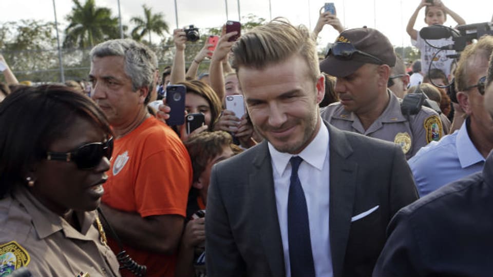 David Beckham wird nach der Pressekonferenz umringt von Fans und Fotografen.
