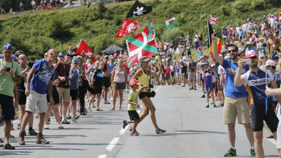 Fans laufen über die Strasse der Tour de France