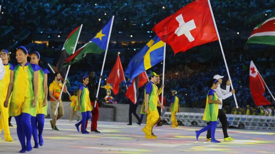 Goldmedaillen-Gewinner Nino Schurter trägt an der Abschlusszeremonie in Rio die Schweizer Fahne.
