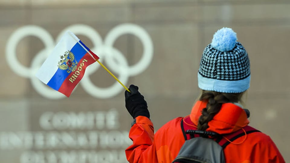 Eine russische Flagge vor dem Logo der Olympischen Ringe. Symbolbild.