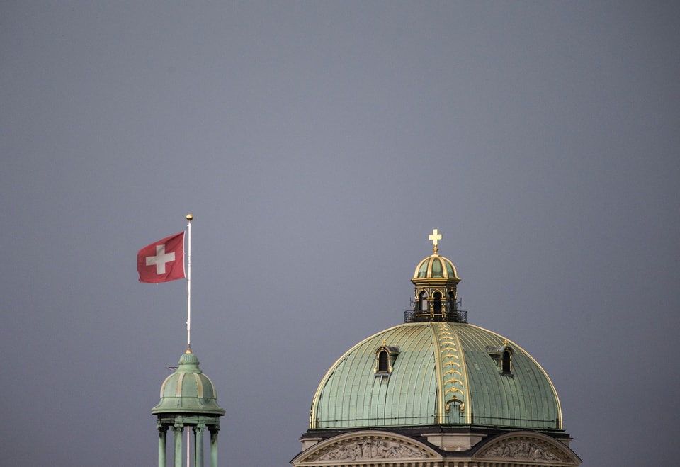 Die Kuppel des Bundeshauses mit Turm und Schweizerfahne.