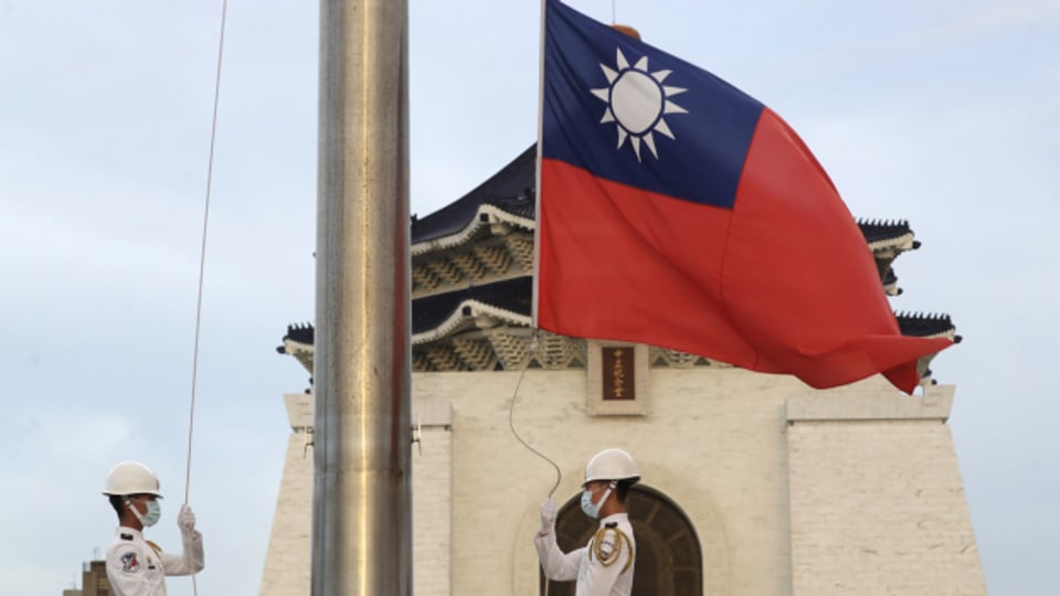 Symbolbild: Zwei Soldaten hissen die Nationalflagge während der täglichen Flaggenzeremonie auf dem Freiheitsplatz der Chiang Kai-shek Memorial Hall in Taipeh.