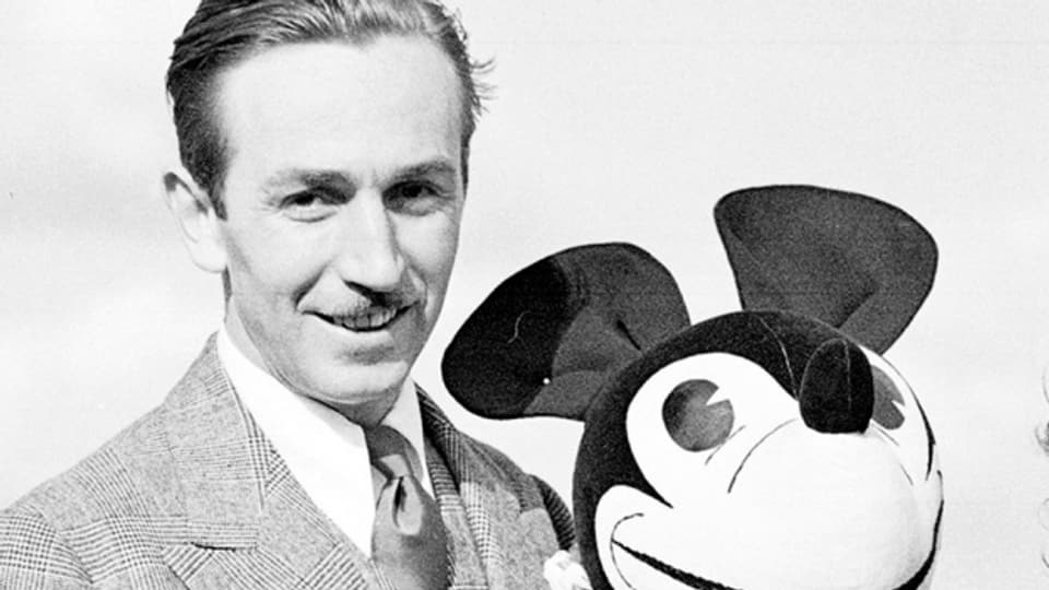 Walt Disney posiert 1935 mit einer Micky Maus-Puppe in London.