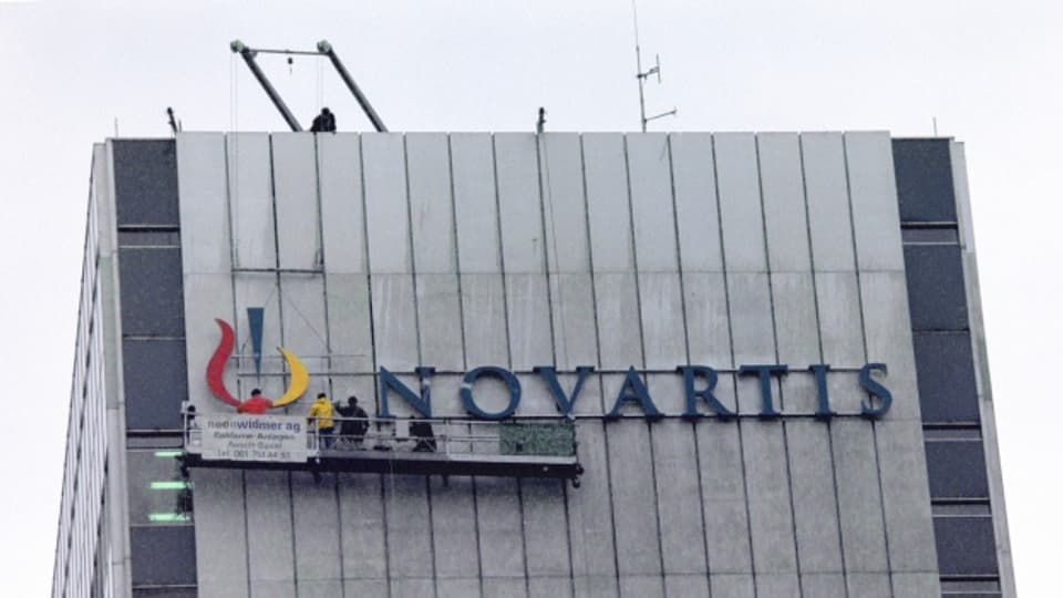 Der neue Novartis-Schriftzug wird am Hauptsitz montiert