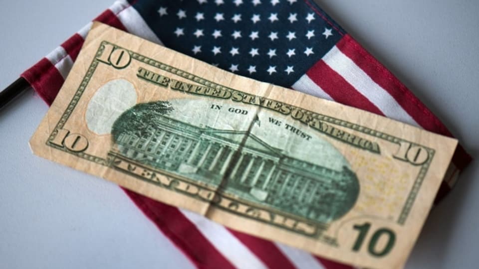 Eine 10-Dollar-Note auf einer US-amerikanischen Flagge.