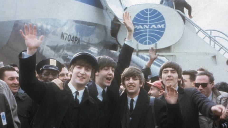Die Beatles vor der PanAm-Maschine, zusammen mit Journalisten