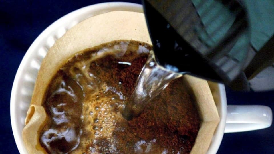 Heisses Wasser wird in Kaffee-Filter gegossen