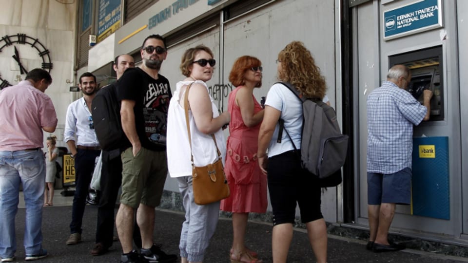 Menschen stehen in Griechenland Schlange vor Bankomaten.