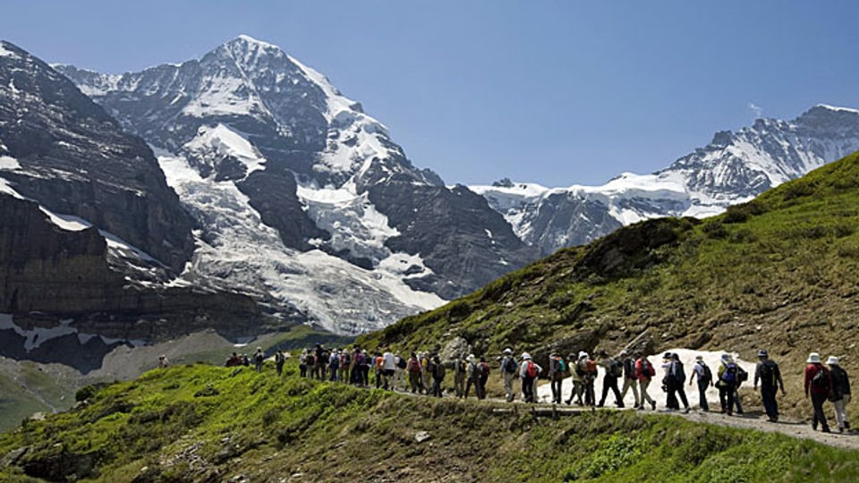 Japanische TouristInnen auf einer Wanderung oberhalb Grindelwalds geniessen den Blick aufMönch und Jungfrau.