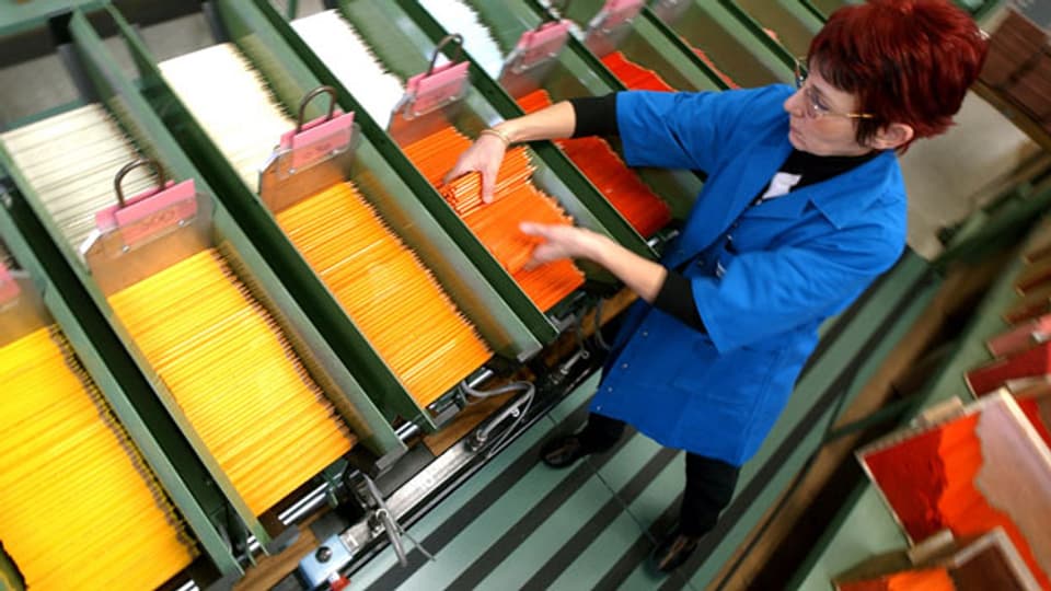 Eine Frau arbeitet an einer Maschine in der Fabrik der Firma Caran d'Ache in Genf.