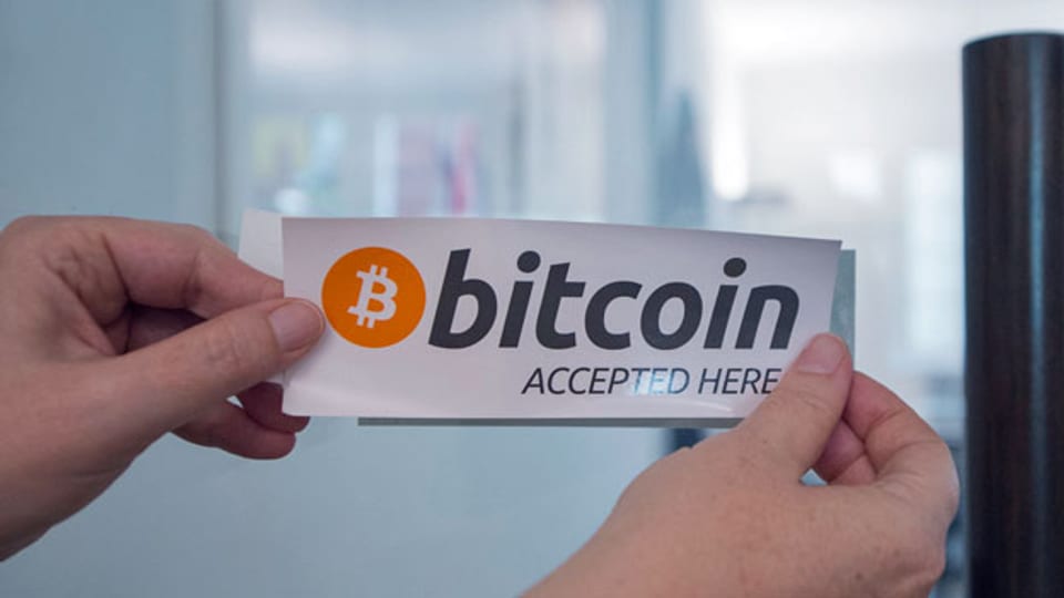 Ein Bitcoin-Kleber an der Tür zur Zuger Stadtverwaltung anlässlich der ersten Bitcoin Transaktion in einer Stadtverwaltung im Juli 2016 in der Stadtverwaltung der Stadt Zug.