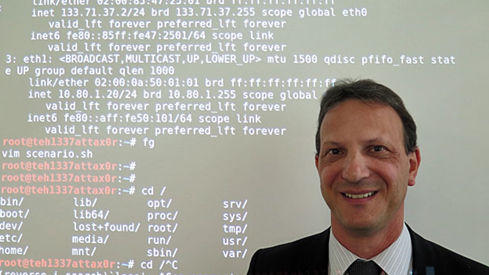 Diego Schmidlin leitet das Ruag-Trainingszentrum für Cyber-Sicherheit in Bern. Er steht vor einer Wand mit Codes, mithilfe derer man Cyber-Kriminelle abwehren kann.
