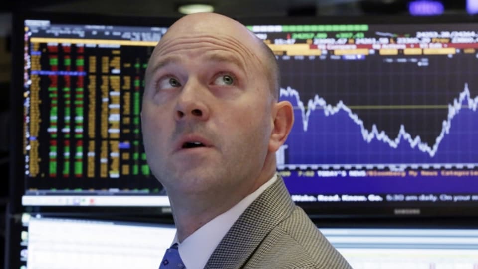 Ein Börsenhändler in New York schaut gebannt auf die schwankenden Kurse.