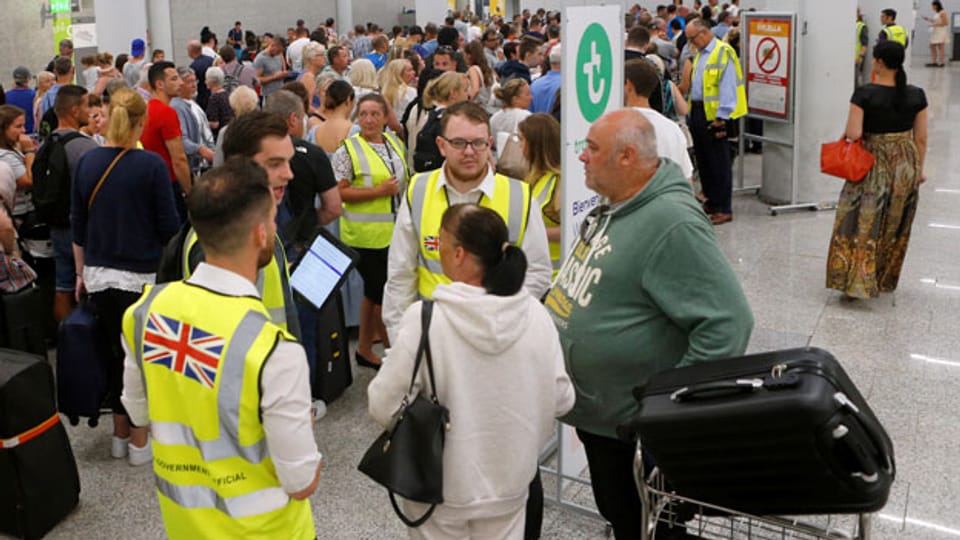 Passagiere an den Check-Schalter von Thomas Cook am Flughafen von Mallorca, nachdem das älteste Reiseunternehmen der Welt zusammengebrochen ist.