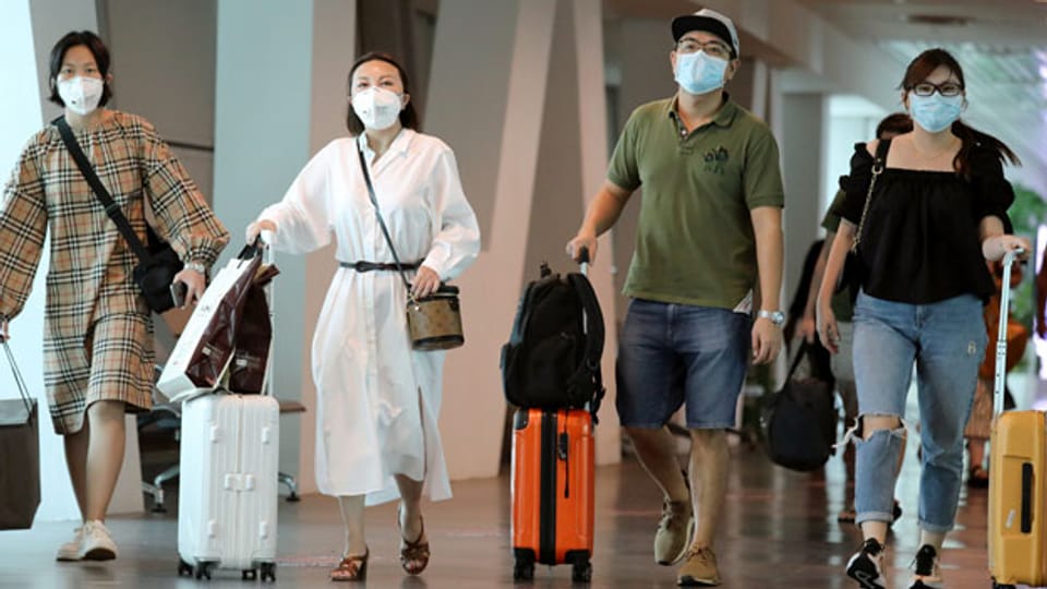 Touristinnen und Touristen am Flughafen von Kuala Lumpur, Malaysia. Symbolbild.