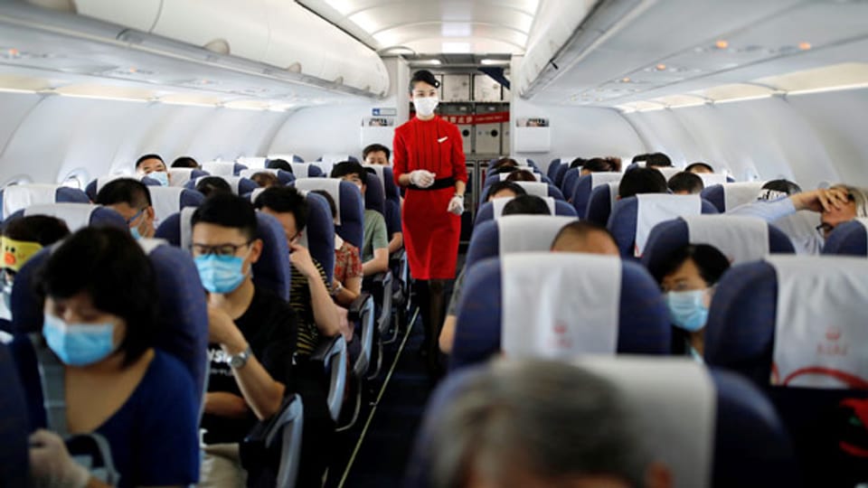 Flugbegleiterin und Passagiere in einem Flugzeug. Symbolbild.