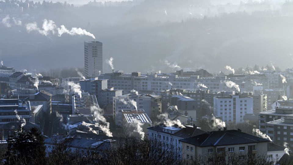 Rauch aus Schornsteinen auf den Dächern von Gebäuden in Freiburg.
