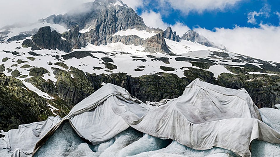 Modellrechnungen zeigen, dass bei gleichbleibendem Klimawandel die Schweizer Gletscher bis Ende dieses Jahrhunderts nur noch als winzige Reste bestehen werden. Rund 90 Prozent des Eises werden unter diesen Bedingungen verschwinden. Bild: Rhonegletscher am Furkapass; die Blachen sollen die Schmelze verlangsamen.