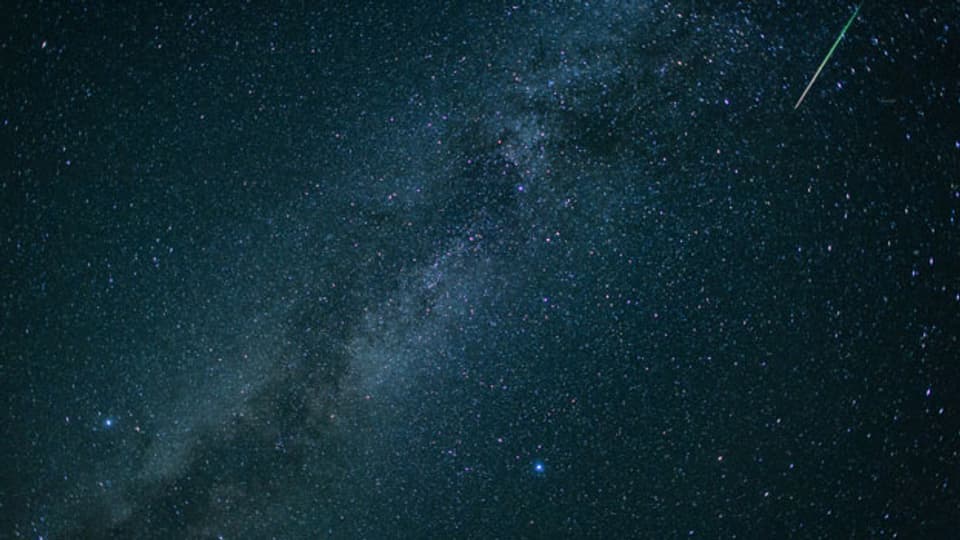 Eine Sternschnuppe leuchtet neben der Milchstraße am Himmel über dem Walchensee. Symbolbild.