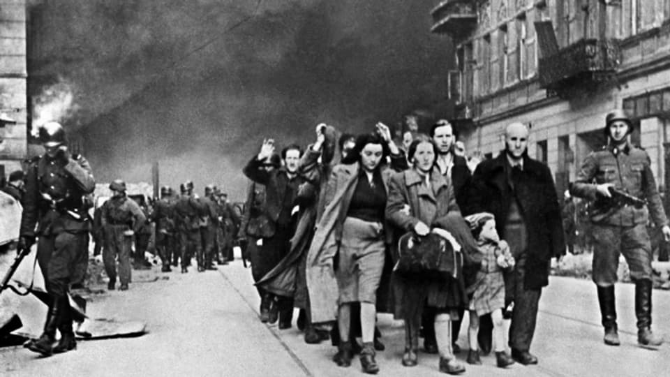 Eine Gruppe polnischer Juden wird nach dem gescheiterten Aufstand von Soldaten der SS aus dem brennenden Warschauer Ghetto abgeführt.