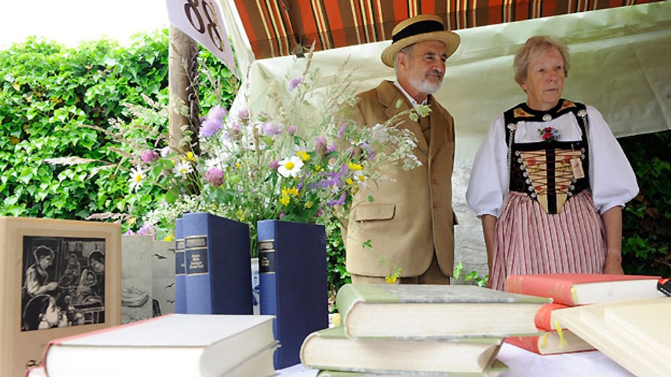 2010 am Gotthelf-Märit in Sumiswald: Besucher in Kleidung aus Gotthelfs Zeiten am Stand mit Büchern von Jeremias Gotthelf.