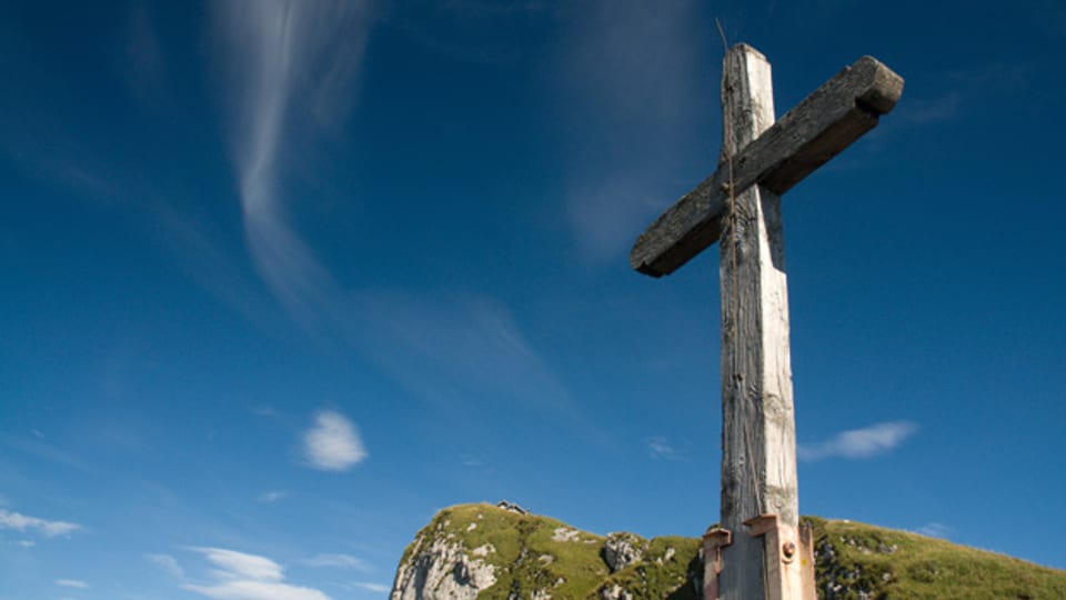 Dient häufig als Symbol für Jodlermessen: ein Kreuz auf einem Berggipfel.