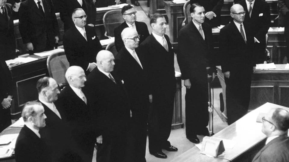 Die Vereidigung des Gesamtbundesrates vor der Vereinigten Bundesversammlung am 17. Dezember 1959. Von links nach rechts: Max Petitpierre (FDP), Paul Chaudet (FDP), Friedrich Traugott Wahlen (BEB), Jean Bourgknecht (CVP), Willy Spühler (SP), Ludwig von Moos (CVP), Hans-Peter Tschudi (SP) und Bundeskanzler Charles Oser.