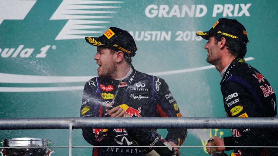 Sebastian Vettel (links) feiert am 17. November 2013 seinen Grandprix-Sieg in Austin, Texas mit einer Champagner-Dusche. Sein Teamkollege Mark Webber feiert als Drittplatzierter mit.