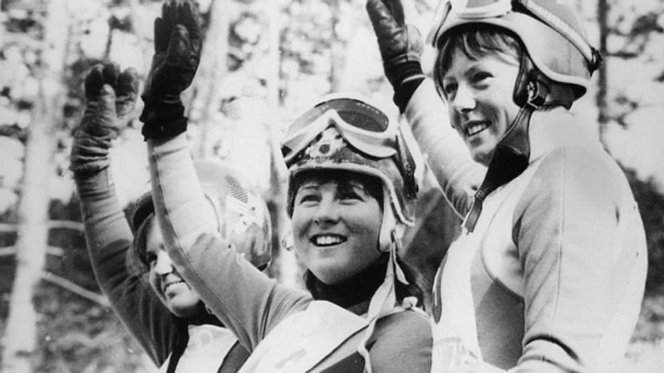 Marie-Theres Nadig 1972 bei der Siegerehrung nach der Abfahrt an den Olympischen Winterspielen in Sapporo. Rechts neben ihr die als Favoritin gehandelte Österreicherin Annemarie Pröll auf Platz 2, links die Drittplatzierte Amerikanerin Susan Corrock.