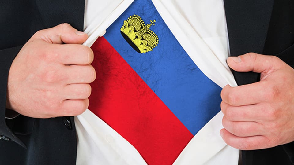 Man(n) zeigt Liechtensteiner Flagge.