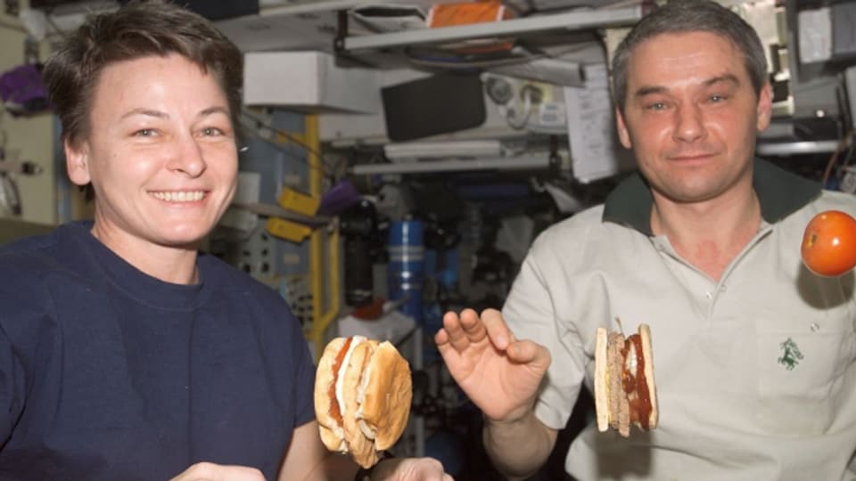 Astronautin Peggy Whitson und Kosmonaut Valery Korzun essen auf der Internationalen Raumstation ISS «fliegende» Hamburger, aufgenommen 2008.