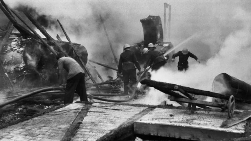 Feuerwehrleute versuchen am 3. März 1945 im Güterbahnhof Basel das durch Bomben entfachte Feuer zu löschen.