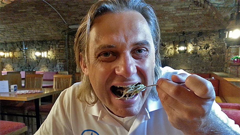 Christian Suter (ORF) geniesst Schweinsbraten mit Knödel und Speckkrautsalat.