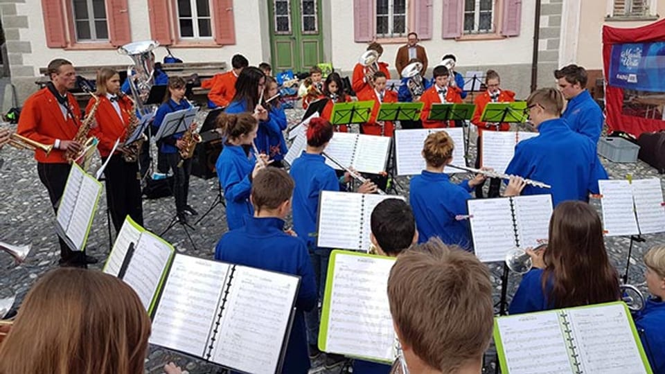 Musica da giuventüna Engiadina Bassa e Musica da giuvenils Valsot auf dem Dorfplatz von Sent.