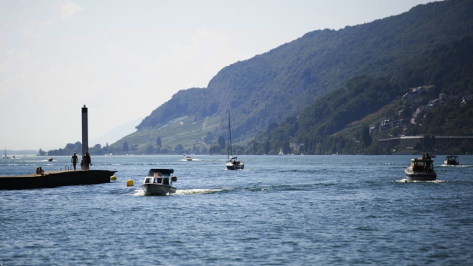 Menschen geniessen das warme Wetter auf Booten am Bielersee in Biel.