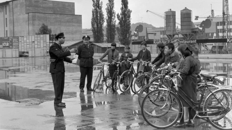 Verkehrspolizisten und an der Fahrradpruefung teilnehmende Schueler bei der Kunstteisbahn in Luzern, aufgenommen am 6. Juni 1966.