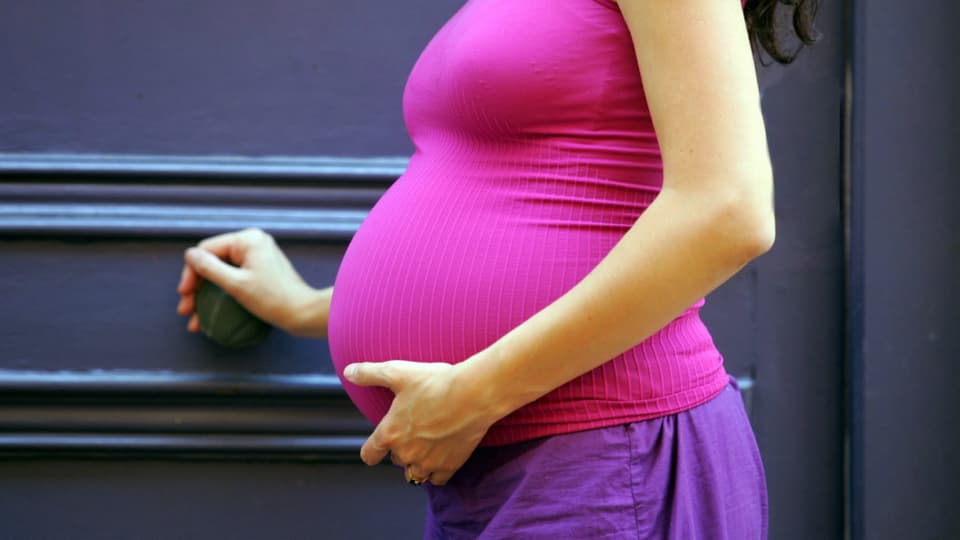 Eine Schwangere hält sich den Bauch